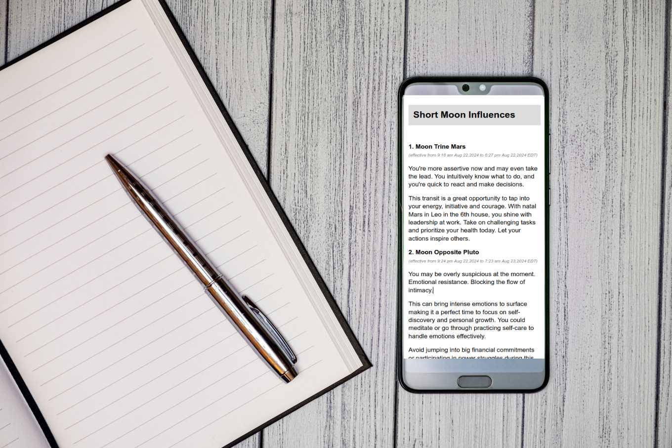 A phone showing the daily transits report next to a journal and pen