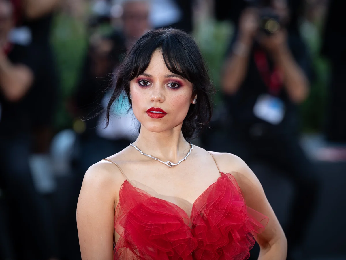 Photo of Jenna Ortega, a Libra actress, in a stunningly beautiful red dress at the 81st Venice Film Festival on August 28, 2024.