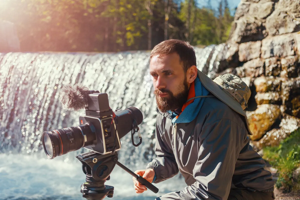 A photo of a man photographing a beautiful outdoors nature scene representing Libra's eye for beauty.