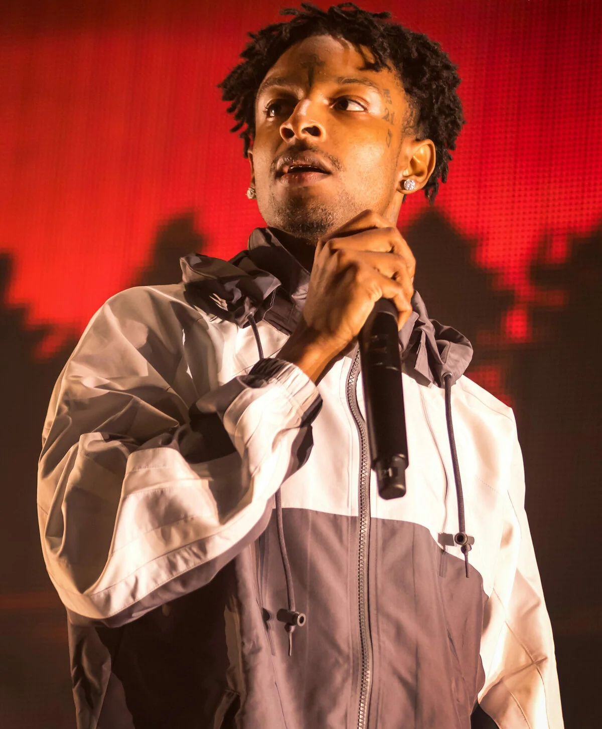 Photo of Libra rapper 21 Savage holding a microphone, performing at the Austin360 Amphitheater in Austin, Texas on June 16, 2018.