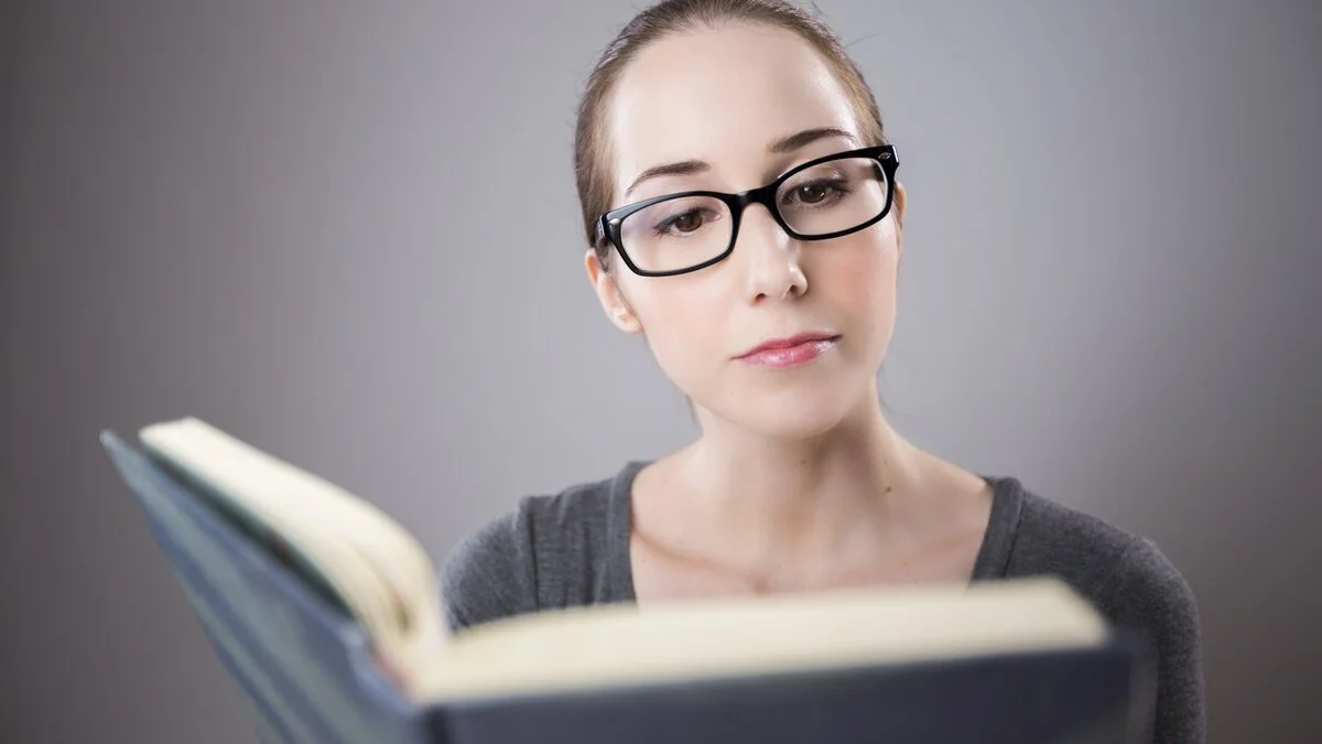 A woman with glasses reading a book
