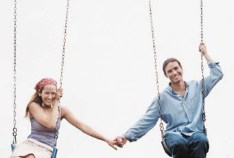 Sagittarius Couple Holding Hands on Swing Set