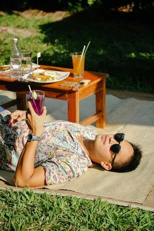 A person relaxing and enjoying the good life with a beverage and food outdoors.