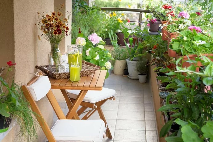 A small garden on a balcony with a patio table.