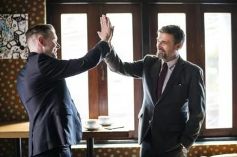Two businessmen in suits giving a high five